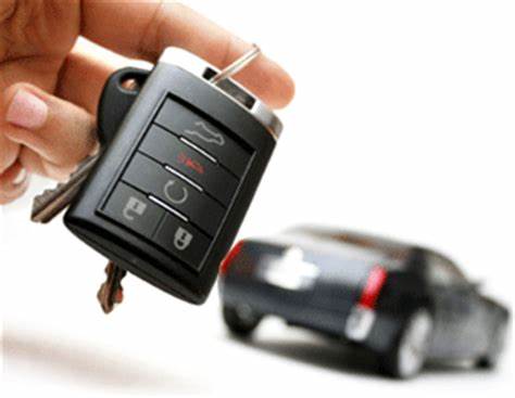 Hand holding car keys with car in background